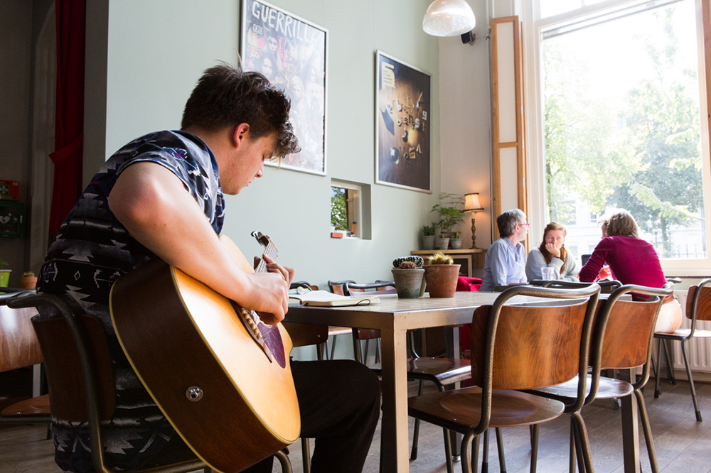 Jongen speelt gitaar in de foyer